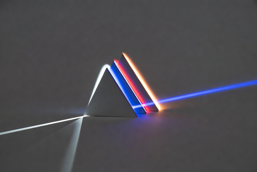 A single light beam splitting through a triangular prism into multiple specialized color bands representing different agent personas